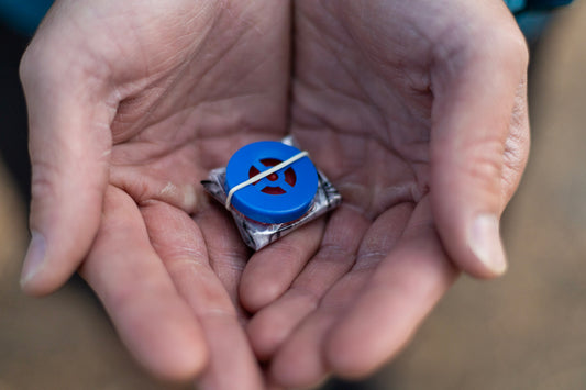 A man holds a tiny CPR mask in his hands