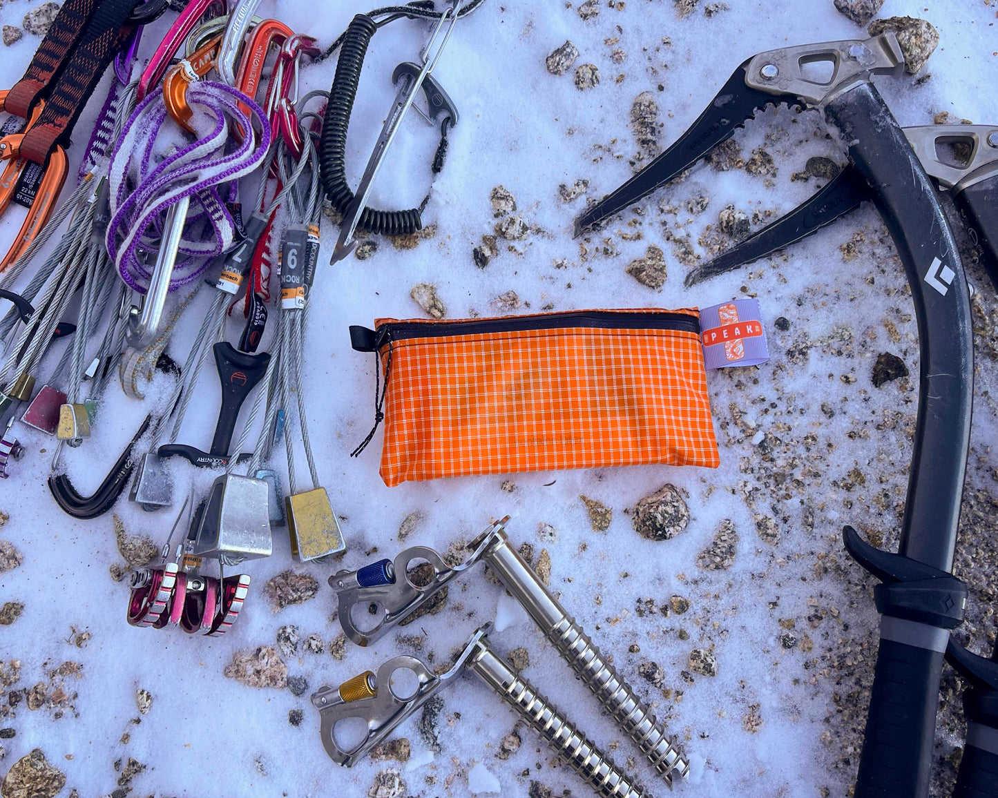 Detail shot of a peak first aid kit in the wilderness surrounded by alpine climbing and ice climbing and trad climbing equipment
