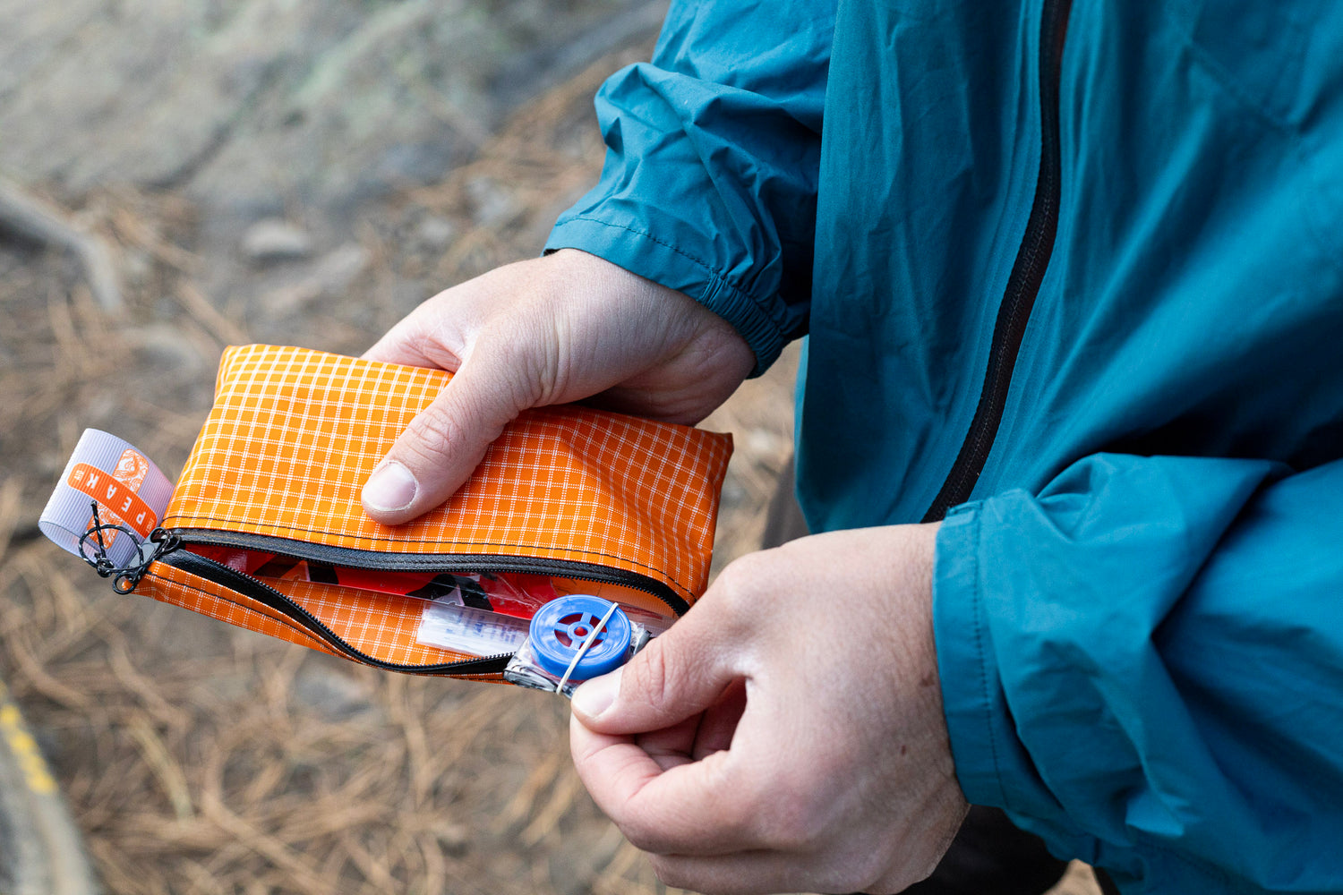 A man pulls a backcountry cpr mask for hiking out of his Peak First Aid Kit.