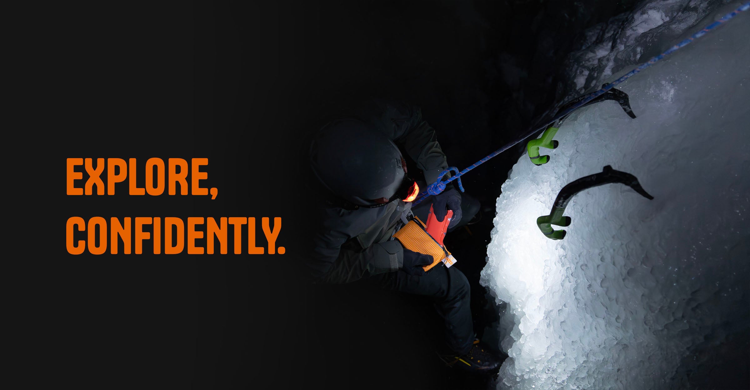 An ice climber removes a tourniquet from a orange pouch in the dark with text "Explore, Confidently"